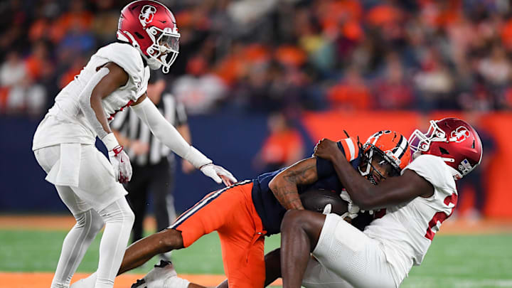 Sep 20, 2024; Syracuse, New York, USA; Stanford Cardinal linebacker David Bailey (right) tackles Syracuse Orange wide receiver Umari Hatcher (5) as cornerback Collin Wright (6) looks on during the second half at the JMA Wireless Dome. Mandatory Credit: Rich Barnes-Imagn Images