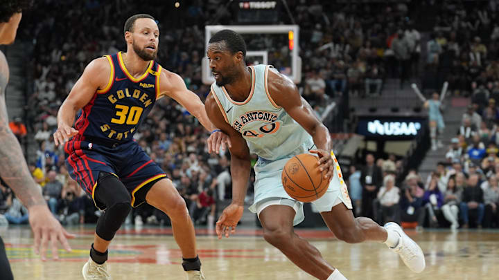 Mar 30, 2025; San Antonio, Texas, USA;  San Antonio Spurs forward Harrison Barnes (40) dribbles past Golden State Warriors guard Stephen Curry (30) in the second half at Frost Bank Center. Mandatory Credit: Daniel Dunn-Imagn Images