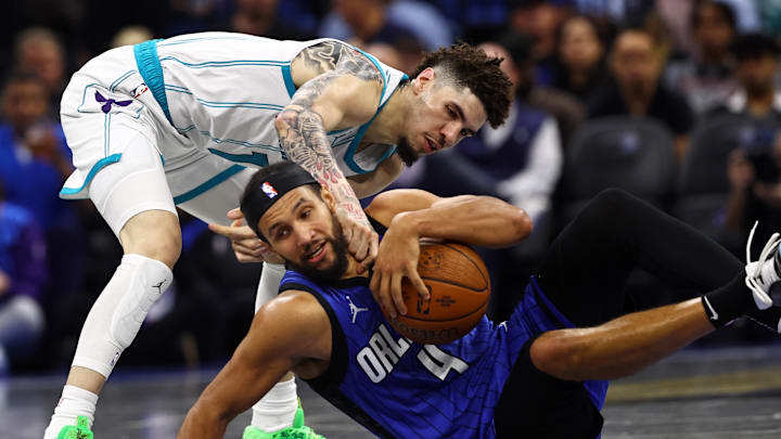Charlotte Hornets guard LaMelo Ball (1) and Orlando Magic guard Jalen Suggs (4) go after the loose ball during the second half at Kia Center.
