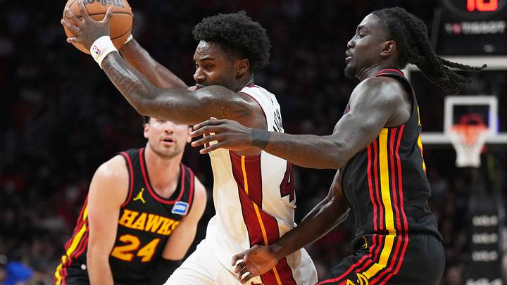 Apr 12, 2026; Miami, Florida, USA;  Miami Heat guard Davion Mitchell (45) drives against Atlanta Hawks forward Corey Kispert (24) and guard Keaton Wallace (2) during the second half at Kaseya Center. Mandatory Credit: Jim Rassol-Imagn Images