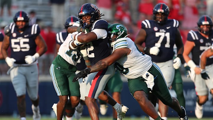Sep 20, 2025; Oxford, Mississippi, USA; Mississippi Rebels running back Damien Taylor (12) runs the ball as Tulane Green Wave defensive back TJ Smith (13) and defensive linemen Eliyt Nairne (90) attempt to make the tackle during the fourth quarter at Vaught-Hemingway Stadium. Mandatory Credit: Petre Thomas-Imagn Images Sep 20, 2025; Oxford, Mississippi, USA; Mississippi Rebels running back Damien Taylor (12) runs the ball as Tulane Green Wave defensive back TJ Smith (13) and defensive linemen Eliyt Nairne (90) attempt to make the tackle during the fourth quarter at Vaught-Hemingway Stadium. Mandatory Credit: Petre Thomas-Imagn Images