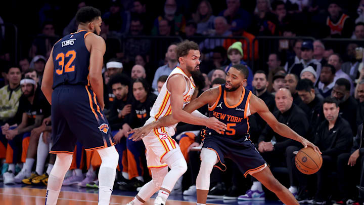 Dec 11, 2024; New York, New York, USA; New York Knicks center Karl-Anthony Towns (32) sets a pick for forward Mikal Bridges (25) against Atlanta Hawks guard Trae Young (11) during the first quarter at Madison Square Garden. Mandatory Credit: Brad Penner-Imagn Images