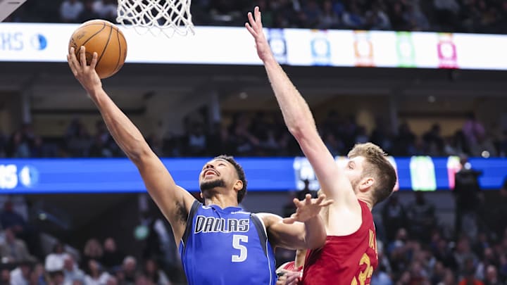 Jan 3, 2025; Dallas, Texas, USA;  Dallas Mavericks guard Quentin Grimes (5) drives to the basket as Cleveland Cavaliers forward Dean Wade (32) defends during the second half at American Airlines Center. Mandatory Credit: Kevin Jairaj-Imagn Images