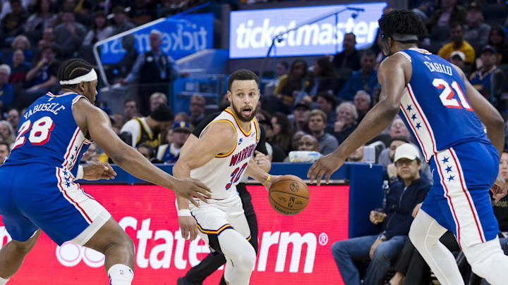 Golden State Warriors guard Stephen Curry (30) drives past Philadelphia 76ers forward Guerschon Yabusele (28) and center Joel Embiid (21) during the third quarter at Chase Center. Mandatory Credit: John Hefti-Imagn Images