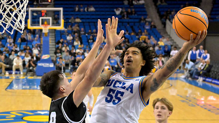 Dec 19, 2025; Los Angeles, California, USA; UCLA Bruins guard Skyy Clark (55) is defended by Cal Poly Mustangs guard Peter Bandelj (9) as he goes for a basket during the first half at Pauley Pavilion presented by Wescom Financial. Mandatory Credit: Jayne Kamin-Oncea-Imagn Images