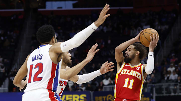 Feb 3, 2025; Detroit, Michigan, USA;  Atlanta Hawks guard Trae Young (11) is defended by Detroit Pistons forward Tobias Harris (12) and guard Cade Cunningham (2) in the second half at Little Caesars Arena. Mandatory Credit: Rick Osentoski-Imagn Images