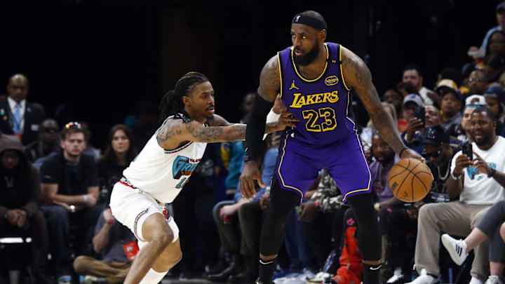 Mar 29, 2025; Memphis, Tennessee, USA; Los Angeles Lakers forward LeBron James (23) dribbles as Memphis Grizzlies guard Ja Morant (12) defends during the third quarter at FedExForum. Mandatory Credit: Petre Thomas-Imagn Images