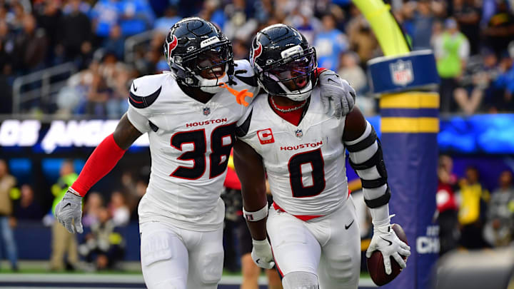 Dec 27, 2025; Inglewood, California, USA;  Houston Texans linebacker Azeez al-Shaair (0) reacts with safety K'Von Wallace (38) after making an interception against the Los Angeles Chargers during the first half at SoFi Stadium. Mandatory Credit: Gary A. Vasquez-Imagn Images