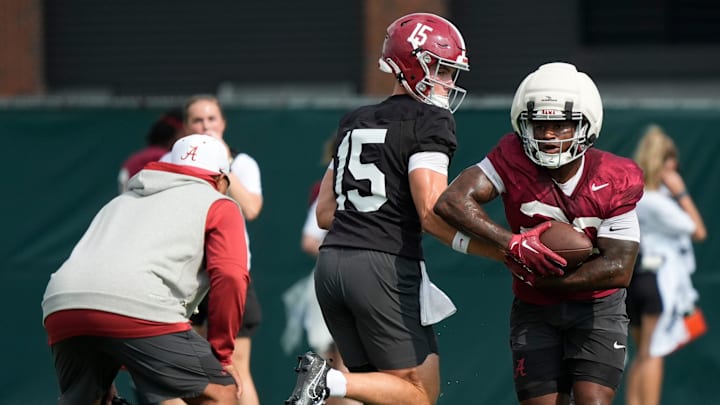 July 30, 2025; Tuscaloosa, AL, USA; Quarterback Ty Simpson hands off to running back Jam Miller during the first practice session of the preseason for the Alabama Crimson Tide.