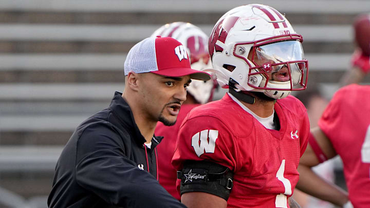Apr 11, 2023; Madison, WI, USA; Wisconsin running backs coach Devon Spalding talks with running back Chez Mellusi (1) during practice Tuesday, April 11, 2023 at Camp Randall Stadium in Madison, Wis. Mandatory Credit: Mark Hoffman-Imagn Images