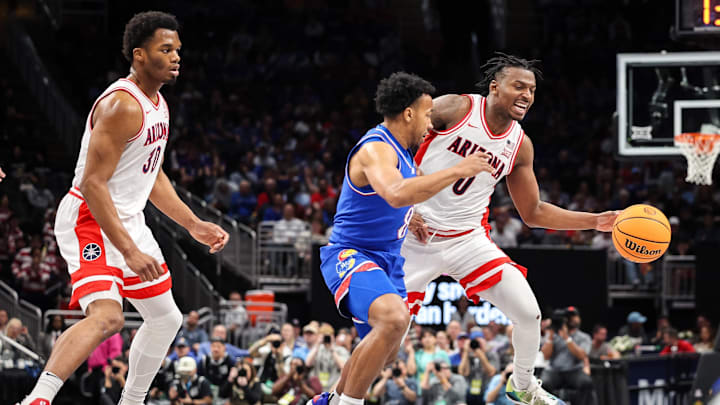 Mar 13, 2025; Kansas City, MO, USA; Arizona Wildcats guard Jaden Bradley (0) drives around Kansas Jayhawks guard David Coit (8) during the first half at T-Mobile Center. Mandatory Credit: William Purnell-Imagn Images