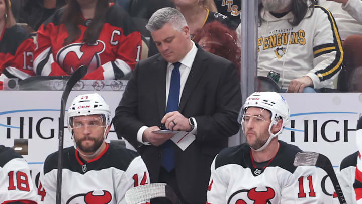 Jan 8, 2026; Pittsburgh, Pennsylvania, USA;  New Jersey Devils head coach Sheldon Keefe makes a note on the bench against the Pittsburgh Penguins during the first period at PPG Paints Arena. Mandatory Credit: Charles LeClaire-Imagn Images