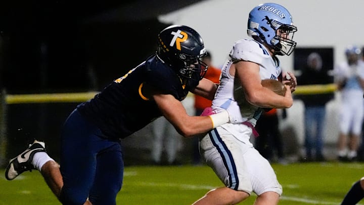 Regina’s Tate Wallace (0) looks to tackle Northeast’s Maxzen Eskildsen (1) during a Class 1A playoff game Oct. 24, 2025 in Iowa City, Iowa.