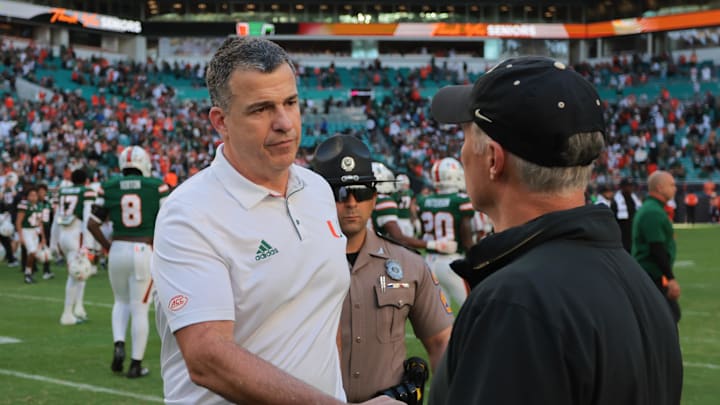 Nov 23, 2024; Miami Gardens, Florida, USA; Miami Hurricanes head coach Mario Cristobal shakes hands with Wake Forest Demon Deacons head coach Dave Clawson after the game at Hard Rock Stadium. Mandatory Credit: Sam Navarro-Imagn Images