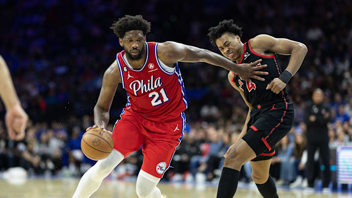 Mar 31, 2023; Philadelphia, Pennsylvania, USA; Philadelphia 76ers center Joel Embiid (21) dribbles past Toronto Raptors forward Scottie Barnes (4) during the third quarter at Wells Fargo Center. Mandatory Credit: Bill Streicher-Imagn Images