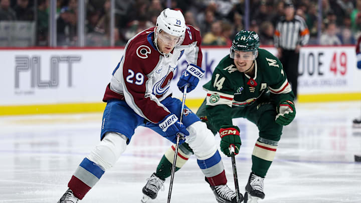 Nov 28, 2025; Saint Paul, Minnesota, USA; Colorado Avalanche center Nathan MacKinnon (29) skates with the puck as Minnesota Wild center Joel Eriksson Ek (14) defends during the third period at Grand Casino Arena. Mandatory Credit: Matt Krohn-Imagn Images