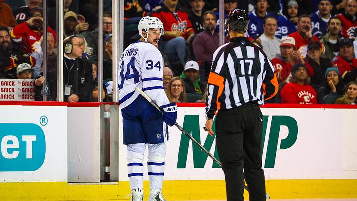 Oct 26, 2026; Calgary, Alberta, CAN; Toronto Maple Leafs center Auston Matthews (34) and referee Frederick L'ecuyer (17) exchanges words during the third period at Scotiabank Saddledome. Mandatory Credit: Sergei Belski-Imagn Images