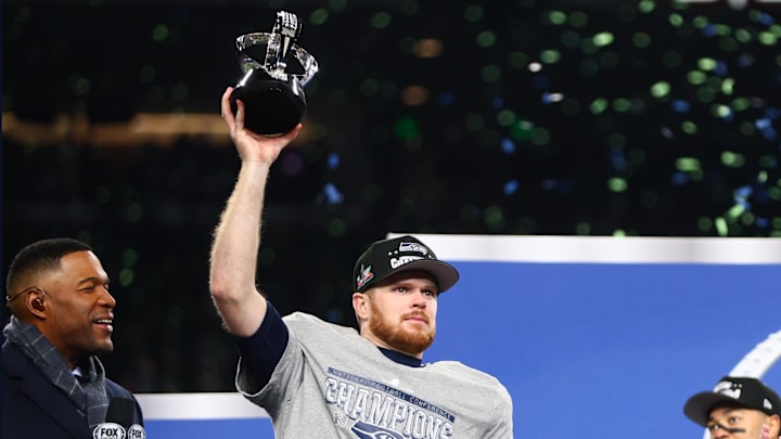 Jan 25, 2026; Seattle, WA, USA; Seattle Seahawks quarterback Sam Darnold (14) celebrates with the trophy on the podium after defeating the Los Angeles Rams in the 2026 NFC Championship Game at Lumen Field. Mandatory Credit: Kevin Ng-Imagn Images