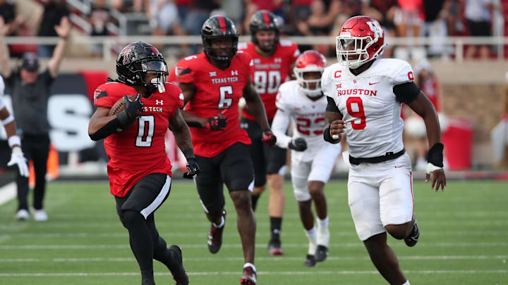 Sep 30, 2023; Lubbock, Texas, USA;  Houston Cougars defensive end Nelson Caesar (9) pursues Texas Tech Red Raiders running back Cam   Ron Valdez (0) in the second half at Jones AT&T Stadium and Cody Campbell Field. Mandatory Credit: Michael C. Johnson-Imagn Images