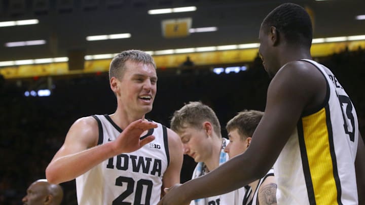 Iowa   s Payton Sandfort (20) gets high-fives from teammates as he comes off the court. 