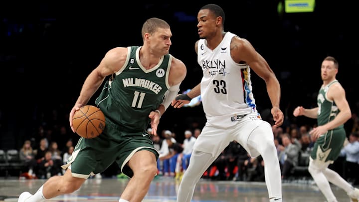 Feb 28, 2023; Brooklyn, New York, USA; Milwaukee Bucks center Brook Lopez (11) drives to the basket against Brooklyn Nets center Nic Claxton (33) during the third quarter at Barclays Center. Mandatory Credit: Brad Penner-Imagn Images