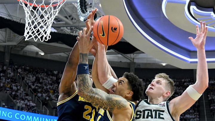 Jan 30, 2026; East Lansing, Michigan, USA;  Michigan State Spartans forward Jaxon Kohler (0) battles Michigan Wolverines guard Elliot Cadeau (3) and forward Morez Johnson Jr. (21) for a rebound during the second half at Jack Breslin Student Events Center. Mandatory Credit: Dale Young-Imagn Images