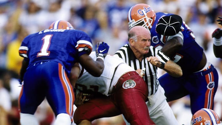 Nov 22, 1997; Gainesville, FL, USA; FILE PHOTO; Florida Gators linebacker Tony George (1) and Reggie McGrew (92) tackle Florida State Seminoles quarterback Thad Busby (12) as an official is caught in the middle of the play at Ben Hill Griffin Stadium. Mandatory Credit: RVR Photos-Imagn Images 