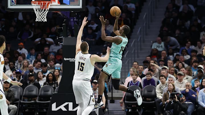 Feb 1, 2025; Charlotte, North Carolina, USA; Charlotte Hornets forward Moussa Diabate (14) shoots over Denver Nuggets center Nikola Jokic (15) during the second quarter at Spectrum Center. Mandatory Credit: Brian Westerholt-Imagn Images