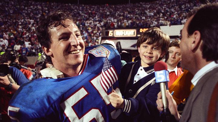 Jan 27, 1991; Tampa, FL, USA; FILE PHOTO; New York Giants linebacker Gary Reasons (55) holds his son on the field during an interview after defeating the Buffalo Bills during Super Bowl XXV at Tampa Stadium. The Giants defeated the Bills 19-20. Mandatory Credit: Darr Beiser-Imagn Images Jan 27, 1991; Tampa, FL, USA; FILE PHOTO; New York Giants linebacker Gary Reasons (55) holds his son on the field during an interview after defeating the Buffalo Bills during Super Bowl XXV at Tampa Stadium. The Giants defeated the Bills 19-20. Mandatory Credit: Darr Beiser-Imagn Images