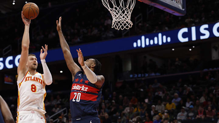 Nov 25, 2025; Washington, District of Columbia, USA; Atlanta Hawks center Kristaps Porzingis (8) shoots the ball over Washington Wizards center Alex Sarr (20) in the first half at Capital One Arena. Mandatory Credit: Geoff Burke-Imagn Images