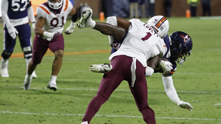 Nov 25, 2023; Charlottesville, Virginia, USA; Virginia Cavaliers wide receiver Malik Washington (4) is tackled by Virginia Tech Hokies cornerback Dante Lovett (1) during the third quarter at Scott Stadium. Mandatory Credit: Geoff Burke-Imagn Images
