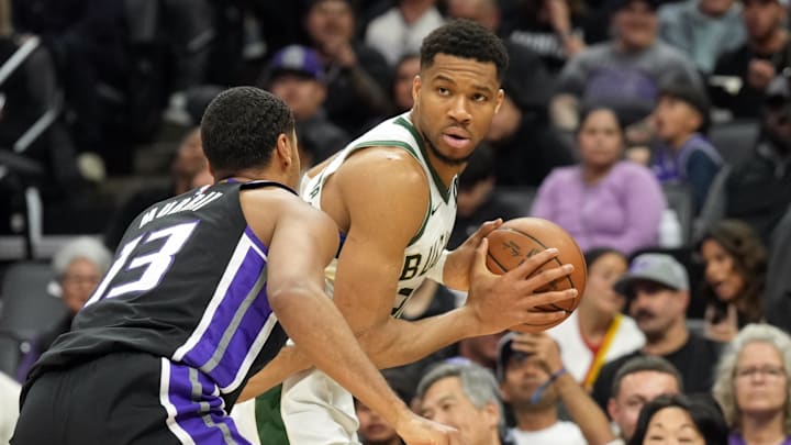 Mar 22, 2025; Sacramento, California, USA; Milwaukee Bucks forward Giannis Antetokounmpo (center) handles the ball against Sacramento Kings forward Keegan Murray (13) during the second quarter at Golden 1 Center. Mandatory Credit: Darren Yamashita-Imagn Images