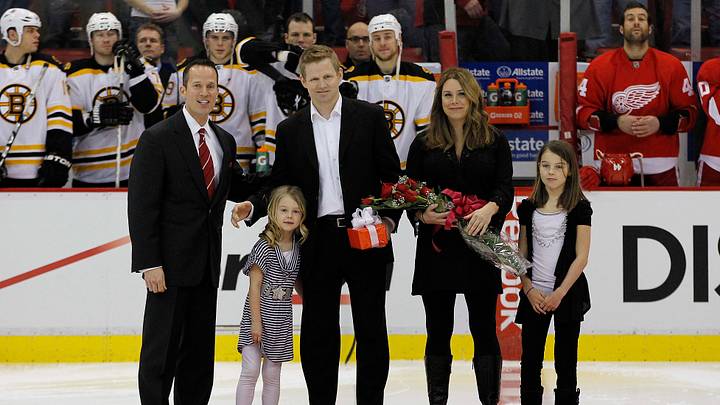 Feb 13, 2011;  Detroit, MI, USA; Detroit Red Wings owner Christopher Ilitch (left) poses with goalie Chris Osgood (30) and Osgood's family to recognize him as the 10th goalie in NHL history to win 400 games before the game against the Boston Bruins at Joe Louis Arena. Mandatory Credit: Leon Halip-USA TODAY Sports