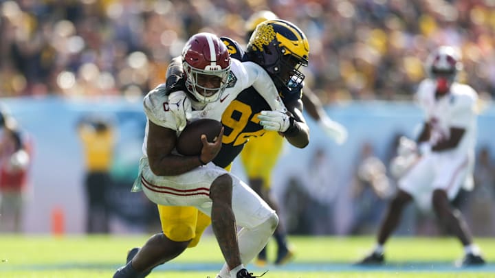 Dec 31, 2024; Tampa, FL, USA;  Alabama Crimson Tide quarterback Jalen Milroe (4) is sacked by Michigan Wolverines defensive lineman Ike Iwunnah (92) in the third quarter during the ReliaQuest Bowl at Raymond James Stadium. Mandatory Credit: Nathan Ray Seebeck-Imagn Images