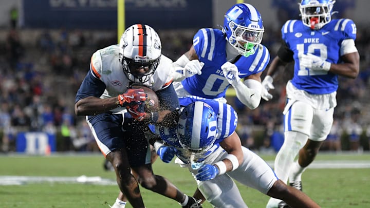 Nov 15, 2025; Durham, North Carolina, USA;  Virginia Cavaliers wide receiver Trell Harris (11) takes a hit from Duke Blue Devils saftey Ma'khi Jones (26) during the third quarter at Wallace Wade Stadium. Mandatory Credit: Zachary Taft-Imagn Images