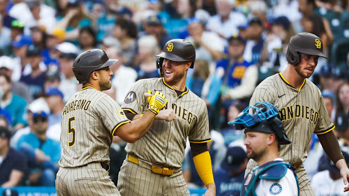 Aug 26, 2025; Seattle, Washington, USA; San Diego Padres center fielder Ramón Laureano (5) celebrates with left fielder Gavin Sheets (30) after hitting a grand slam home run against the Seattle Mariners during the first inning at T-Mobile Park. San Diego Padres first baseman Ryan O'Hearn (32) returns to the dugout at right; O'Hearn and left fielder Gavin Sheets (30) both also scored on the hit by Laureano. Mandatory Credit: Joe Nicholson-Imagn Images
