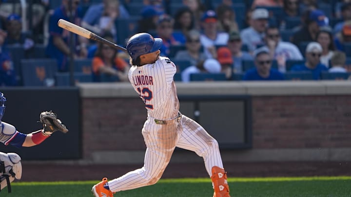 Sep 14, 2025; New York City, New York, USA; New York Mets shortstop Francisco Lindor (12) hits a single against the Texas Rangers during the seventh inning at Citi Field. Mandatory Credit: Gregory Fisher-Imagn Images