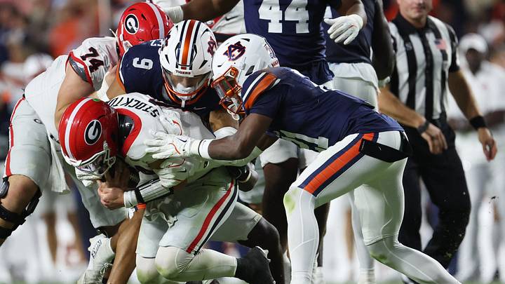 Oct 11, 2025; Auburn, Alabama, USA;  Georgia Bulldogs quarterback Gunner Stockton (14) is tackled by Auburn Tigers linebacker Elijah Melendez (9) and safety Anquon Fegans (21) during the fourth quarter at Jordan-Hare Stadium. Mandatory Credit: John Reed-Imagn Images