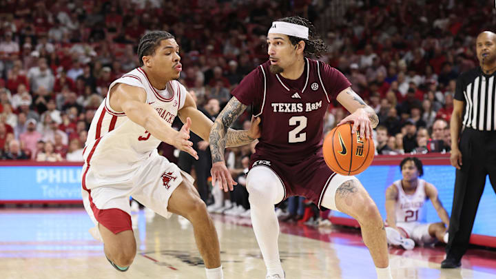 Feb 25, 2026; Fayetteville, Arkansas, USA; Texas A&M Aggies guard Pop Isaacs (2) drives against Arkansas Razorbacks guard Darius Acuff Jr (5) during the first half at Bud Walton Arena. Mandatory Credit: Nelson Chenault-Imagn Images