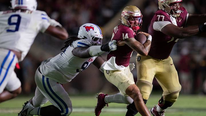 Florida State Seminoles quarterback Ashton Daniels (14) tries to outrun a tackle. The SMU Mustangs defeated the Florida State Seminoles 27-24 at Doak Campbell Stadium after a game that kicked off on Monday, Sept. 7, 2026.