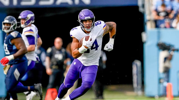 Nov 17, 2024; Nashville, Tennessee, USA;  Minnesota Vikings tight end Josh Oliver (84) runs the ball after a made catch against the Tennessee Titans during the first half at Nissan Stadium. Mandatory Credit: Steve Roberts-Imagn Images