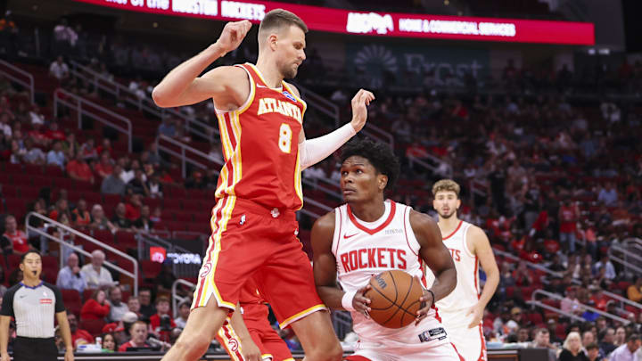 Oct 6, 2025; Houston, Texas, USA; Houston Rockets guard Amen Thompson (1) drives to the basket as Atlanta Hawks forward/center Kristaps Porzingis (8) defends during the first quarter at Toyota Center. Mandatory Credit: Troy Taormina-Imagn Images
