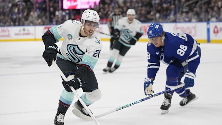 Nov 30, 2023; Toronto, Ontario, CAN; Seattle Kracken forward Alex Wennberg (21) carries the puck around Toronto Maple Leafs forward William Nylander (88) during overtime at Scotiabank Arena. Mandatory Credit: John E. Sokolowski-Imagn Images