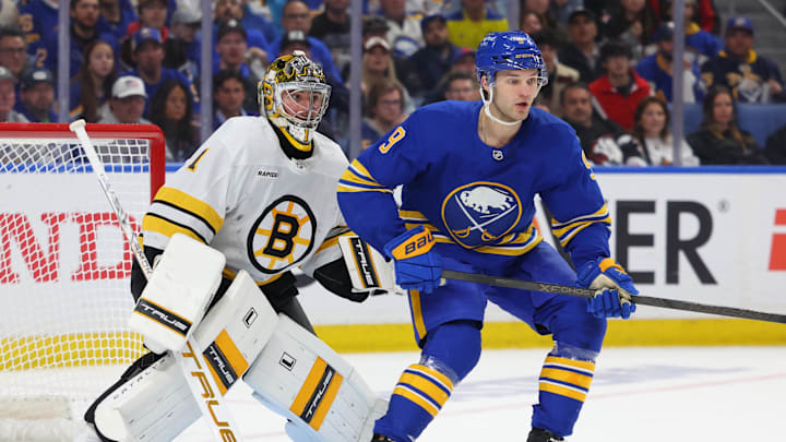 Apr 21, 2026; Buffalo, New York, USA; Boston Bruins goaltender Jeremy Swayman (1) and Buffalo Sabres center Josh Norris (9) look for the puck during the second period in game two of the first round of the 2026 Stanley Cup Playoffs at KeyBank Center. Mandatory Credit: Timothy T. Ludwig-Imagn Images