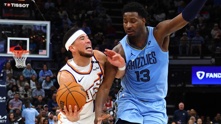 Feb 25, 2025; Memphis, Tennessee, USA; Phoenix Suns guard Devin Booker (1) drives to the basket as Memphis Grizzlies forward Jaren Jackson Jr. (13) defends during the fourth quarter at FedExForum. Mandatory Credit: Petre Thomas-Imagn Images