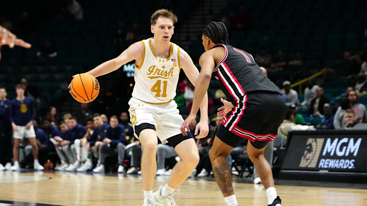 Nov 27, 2024; Las Vegas, Nevada, USA; Notre Dame Fighting Irish guard Matt Allocco (41) dribbles against Houston Cougars guard Milos Uzan (7) during the first half at MGM Grand Garden Arena. Mandatory Credit: Stephen R. Sylvanie-Imagn Images