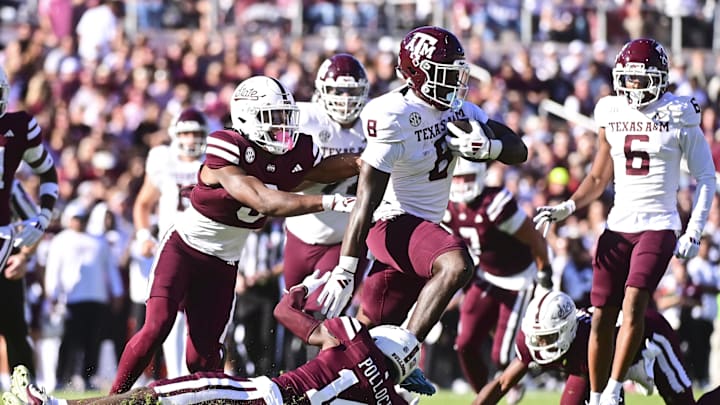 Oct 19, 2024; Starkville, Mississippi, USA; Texas A&M Aggies running back Le'Veon Moss (8) runs the ball against Mississippi State Bulldogs cornerback Brice Pollock (14) during the first quarter at Davis Wade Stadium at Scott Field. Mandatory Credit: Matt Bush-Imagn Images