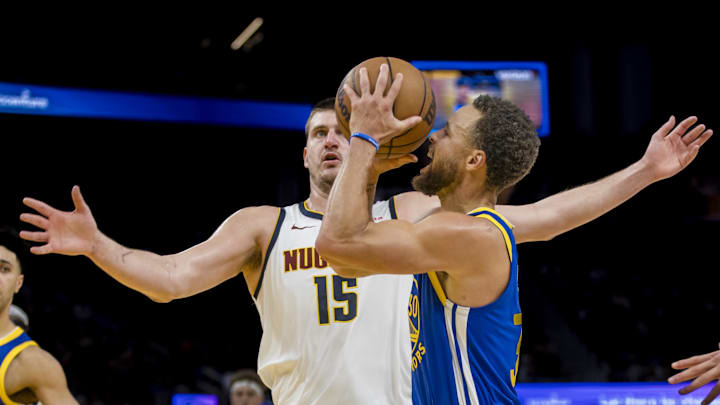 Jan 4, 2024; San Francisco, California, USA; Golden State Warriors guard Stephen Curry (30) is defended by Denver Nuggets center Nikola Jokic (15) during the second half at Chase Center. Mandatory Credit: John Hefti-Imagn Images