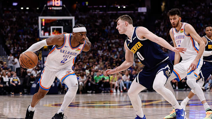 May 11, 2025; Denver, Colorado, USA; Oklahoma City Thunder guard Shai Gilgeous-Alexander (2) controls the ball as Denver Nuggets guard Christian Braun (0) guards in the second quarter during game four of the second round of the 2025 NBA Playoffs at Ball Arena. Mandatory Credit: Isaiah J. Downing-Imagn Images