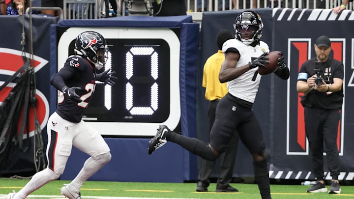 Sep 29, 2024; Houston, Texas, USA;  Jacksonville Jaguars wide receiver Brian Thomas Jr. (7) catches a touchdown against Houston Texans safety Eric Murray (23) in the first quarterat NRG Stadium. Mandatory Credit: Thomas Shea-Imagn Images